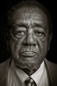 Retrato em preto e branco em close-up de Bobby Seale, cofundador do Partido dos Panteras Negras, já em idade mais avançada.