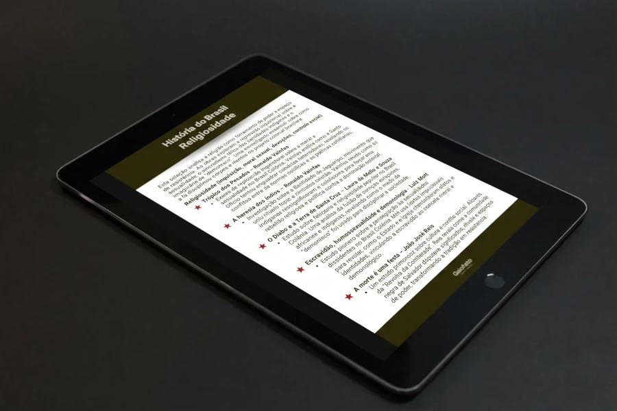Tablet em cima de uma mesa cinza e a preview da lista de leitura sobre religiosidade no Brasil colonial na tela ligada.