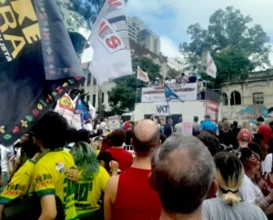 Manifestantes pelo fim da escala 6x1 na Praça Roosevelt em São Paulo, no dia 1º de maio de 2026, de costas para a câmera e de frente para o trailer onde os organizadores da manifestação dialogavam com o povo. Foto: arquivo pessoal.